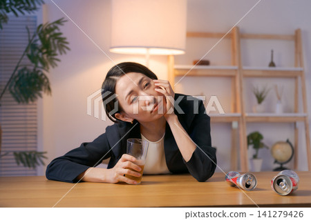 A woman in a suit getting drunk on beer. A woman in a suit getting drunk on beer. 141279426