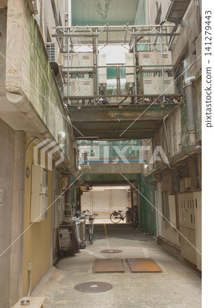 In the back alleys of an old town that retains a Showa-era retro atmosphere, air conditioner units and buildings are densely packed together. 141279443