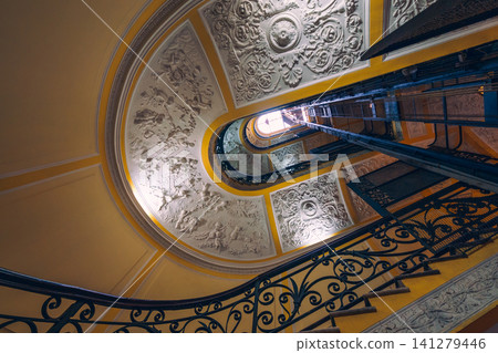 Naples, Italy - November 5, 2018, Panoramic view of antique curved staircase decorated with stucco with wrought iron railings with a floral pattern at Galleria Umberto I, without people, Naples, Italy Naples, Italy - November 5, 2018, Panoramic view of antique curved staircase decorated with stucco with wrought iron railings with a floral pattern at Galleria Umberto I, without people, Naples, Italy 141279446