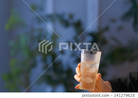 一位女士的手拿著一杯酒。 一位女士的手拿著一杯酒。 141279628