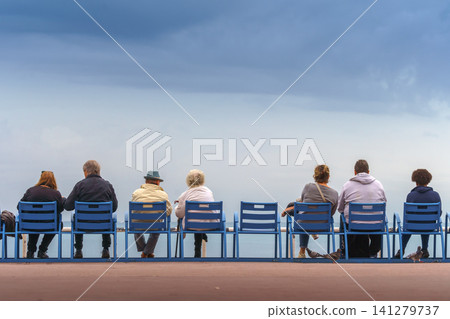 Couples sitting on the bank of the sea feeding pigeons and seagulls. 141279737