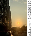 Golden hour sunset over a busy city street with apartment buildings Golden hour sunset over a busy city street with apartment buildings 141280110