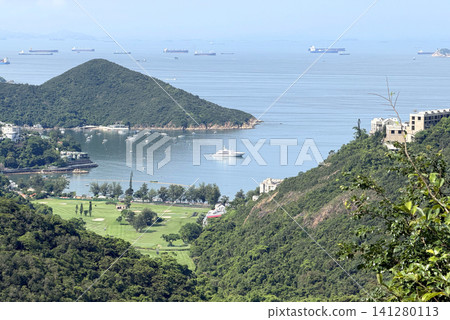 Scenic coastal landscape with golf course and sailboats in a bay Scenic coastal landscape with golf course and sailboats in a bay 141280113