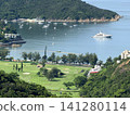 Luxury yacht anchored in a bay with a golf course and lush green hills Luxury yacht anchored in a bay with a golf course and lush green hills 141280114