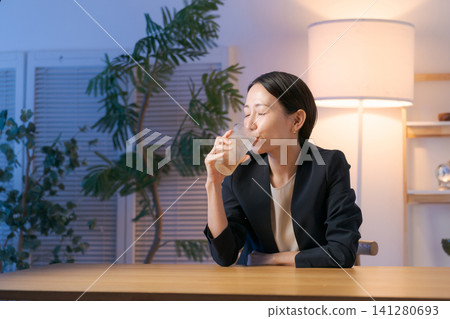A woman smiling while drinking alcohol A woman smiling while drinking alcohol 141280693