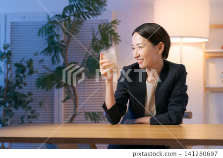 A woman smiling while drinking alcohol A woman smiling while drinking alcohol 141280697