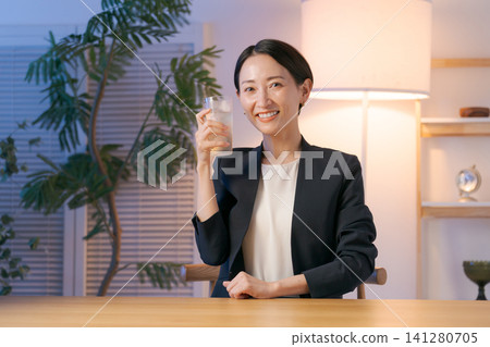 A woman smiling while drinking alcohol A woman smiling while drinking alcohol 141280705