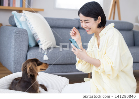 A woman taking a photo of her dog with her smartphone A woman taking a photo of her dog with her smartphone 141280840