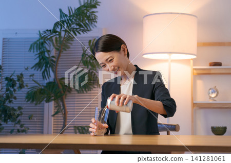 一名女子麵帶微笑地喝酒 一名女子麵帶微笑地喝酒 141281061