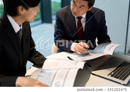 A boss giving work advice to a subordinate A boss giving work advice to a subordinate 141281475