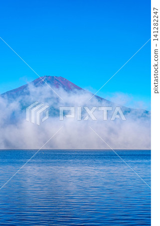 [Mt. Fuji Image] The red Mt. Fuji and sea of clouds bathed in the morning glow as seen from Lake Yamanaka [Yamanashi Prefecture] 141282247