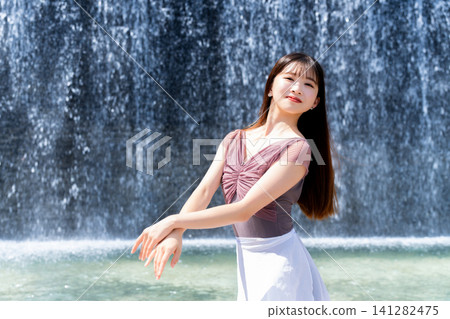 Ballerina dancing in front of a wall of water Ballerina dancing in front of a wall of water 141282475