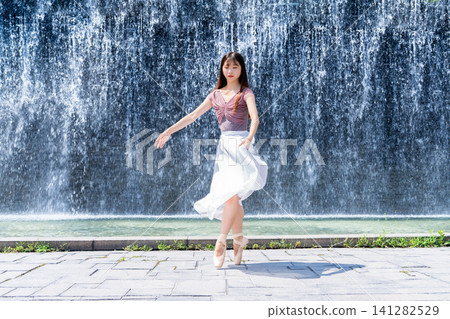 Ballerina dancing in front of a wall of water Ballerina dancing in front of a wall of water 141282529