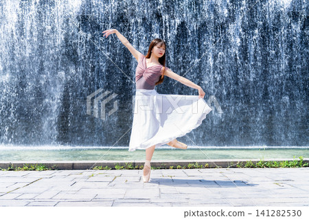 Ballerina dancing in front of a wall of water Ballerina dancing in front of a wall of water 141282530