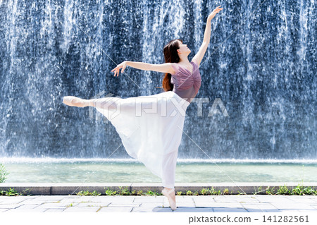 Ballerina dancing in front of a wall of water Ballerina dancing in front of a wall of water 141282561