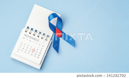 Diabetes Day concept, Blue ribbon with a red blood drop with calendar over a light blue background with copy space Diabetes Day concept, Blue ribbon with a red blood drop with calendar over a light blue background with copy space 141282702