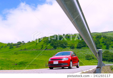 A low-angle shot of a red car driving across a plateau. A low-angle shot of a red car driving across a plateau. 141283117