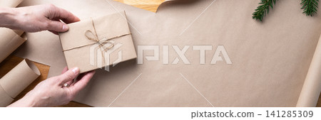 Hands holding wrapped Christmas gift banner Hands holding wrapped Christmas gift banner 141285309