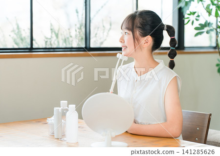 兒童、女孩、小學生、國中生、高中生將按摩滾輪塗抹於臉部線條 兒童、女孩、小學生、國中生、高中生將按摩滾輪塗抹於臉部線條 141285626