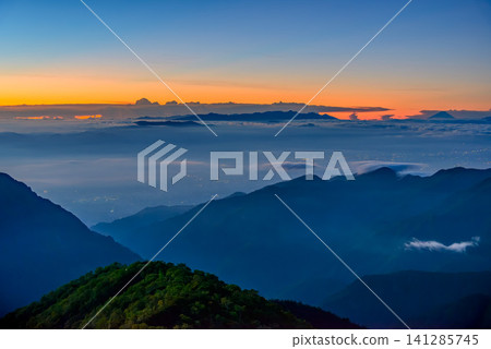 In the early morning of early autumn, the sile between the Yatsugatake Mountains and Mount Fuji can be seen from near the Enzanso mountain hut on Mount Tsubakuro, against a beautiful gradient of the dawn sky. In the early morning of early autumn, the sile between the Yatsugatake Mountains and Mount Fuji can be seen from near the Enzanso mountain hut on Mount Tsubakuro, against a beautiful gradient of the dawn sky. 141285745