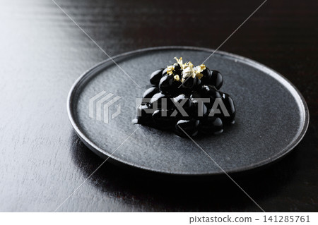 New Year's dishes: Black beans topped with gold leaf (black background) New Year's dishes: Black beans topped with gold leaf (black background) 141285761