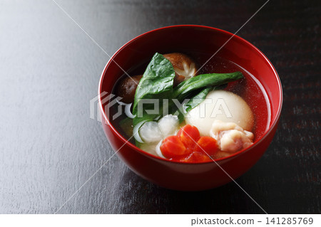 Ozoni (rice cake soup) made with round mochi (rice cakes) - Black background Ozoni (rice cake soup) made with round mochi (rice cakes) - Black background 141285769