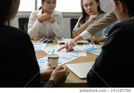 Business team of Asian people analyzing financial charts and data reports during corporate meeting at office conference table Business team of Asian people analyzing financial charts and data reports during corporate meeting at office conference table 141285790