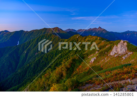 Early autumn morning, a view from near Enzanso mountain hut on Mount Tsubakuro, showing Mount Yarigatake, the Hotaka mountain range, and the ridgeline leading to Mount Otensho bathed in the pink glow of the morning light. Early autumn morning, a view from near Enzanso mountain hut on Mount Tsubakuro, showing Mount Yarigatake, the Hotaka mountain range, and the ridgeline leading to Mount Otensho bathed in the pink glow of the morning light. 141285801