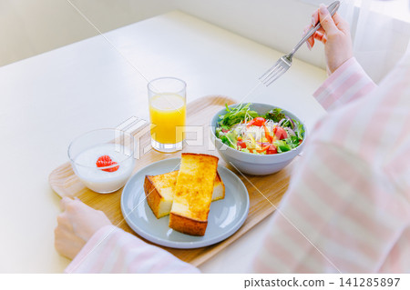 A woman eating breakfast A woman eating breakfast 141285897