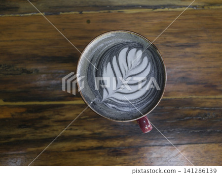 Hot latte in red cup on wooden table Hot latte in red cup on wooden table 141286139