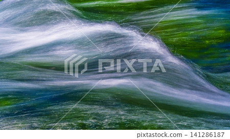 long exposure image of a river flowing through a forest long exposure image of a river flowing through a forest 141286187