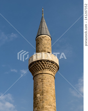 Historic mosque minaret against a clear sky Historic mosque minaret against a clear sky 141287352