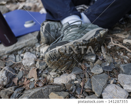 Dirty hiking shoes after trekking in mountains Dirty hiking shoes after trekking in mountains 141287355