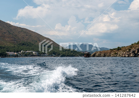 Beautiful sea wave trace from boat with mountain coast Beautiful sea wave trace from boat with mountain coast 141287642
