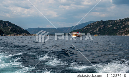 Tourist boats sailing in sea bay surrounded by mountains 141287648