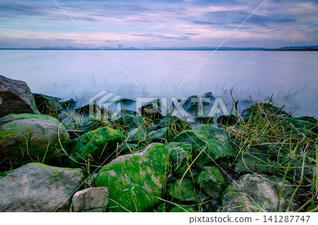 sunset at reservoir made twilight sky colorsshot with slow shutter speed to make all wave smooth sunset at reservoir made twilight sky colorsshot with slow shutter speed to make all wave smooth 141287747