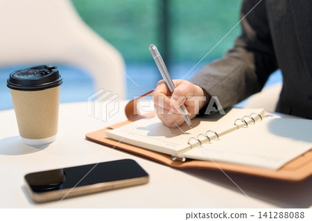 The hands of an Asian businesswoman writing down an idea The hands of an Asian businesswoman writing down an idea 141288088
