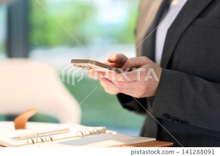 一位女商人的手觸摸著她的智慧型手機 141288091