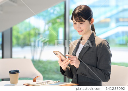 Business woman touching smartphone Business woman touching smartphone 141288092