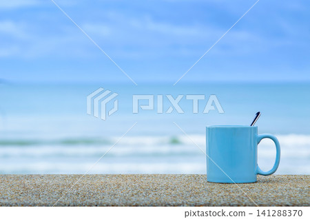 blue cup on the beach with blue sea and sky 141288370