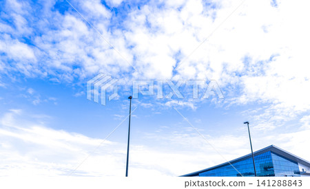 A clear blue sky on a sunny day and a modern building; a modern building exterior. A clear blue sky on a sunny day and a modern building; a modern building exterior. 141288843
