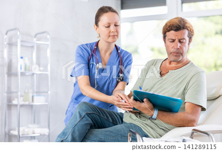 Male patient signs the contract for the operation in clinic of body aesthetics Male patient signs the contract for the operation in clinic of body aesthetics 141289115