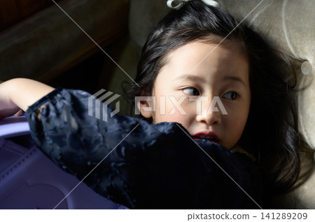 A Japanese girl hugging her schoolbag A Japanese girl hugging her schoolbag 141289209