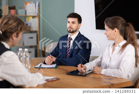 Business professionals discussing topic during corporate meeting at table Business professionals discussing topic during corporate meeting at table 141289331