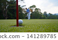 Golfers are putting golf in the evening golf course golf backglound. 141289785