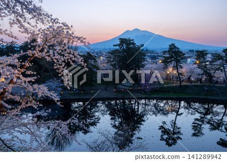 Hirosaki Park, Shimoshirogane-cho, Hirosaki City, Aomori Prefecture: Cherry trees lining the Hasuike moat and the silhouette of Mt. Iwaki at sunset, viewed from the base of Hirosaki Castle's keep. Hirosaki Park, Shimoshirogane-cho, Hirosaki City, Aomori Prefecture: Cherry trees lining the Hasuike moat and the silhouette of Mt. Iwaki at sunset, viewed from the base of Hirosaki Castle's keep. 141289942