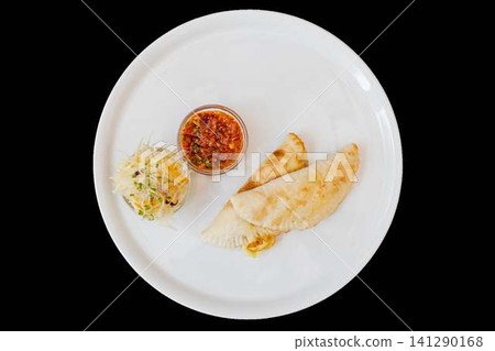 Empanadas with salsa and coleslaw on plate 141290168