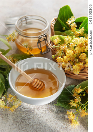 Linden honey in bowl with medicinal flowers Linden honey in bowl with medicinal flowers 141290306