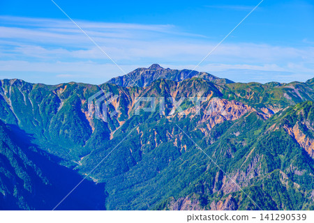 On a clear early autumn day, a view of Mt. Kasagatake towering over the ridge of the Nishikama Ridge, seen from near the summit of Mt. Tsubakuro using a medium telephoto lens. On a clear early autumn day, a view of Mt. Kasagatake towering over the ridge of the Nishikama Ridge, seen from near the summit of Mt. Tsubakuro using a medium telephoto lens. 141290539