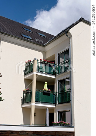 Cozy residential building corner with balconies full of beautiful red geranium flowers in summer Cozy residential building corner with balconies full of beautiful red geranium flowers in summer 141290654